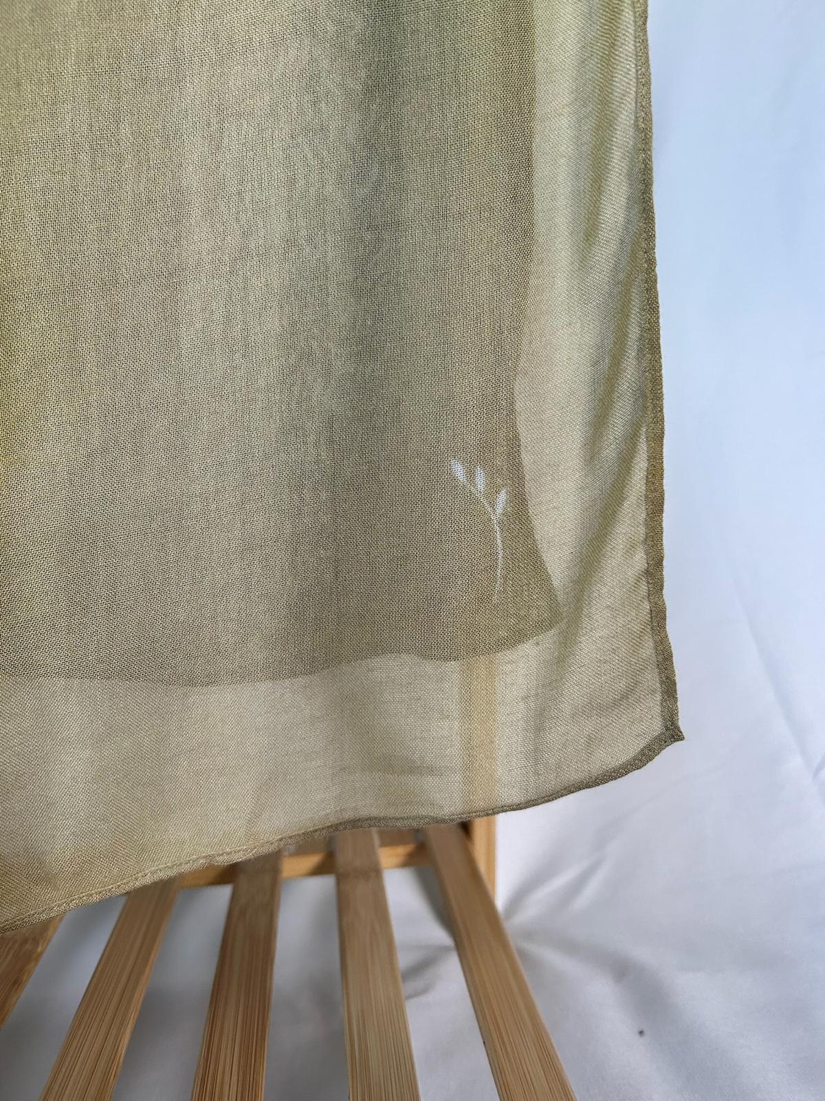 A lightweight olive green sheer scarf with a delicate white embroidered floral motif drapes over a wooden rack.